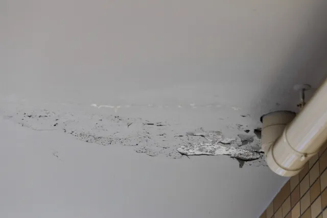 富山市のベランダで防水層のひび割れや塗膜の剥がれ、水たまりなど劣化のサインを確認している様子