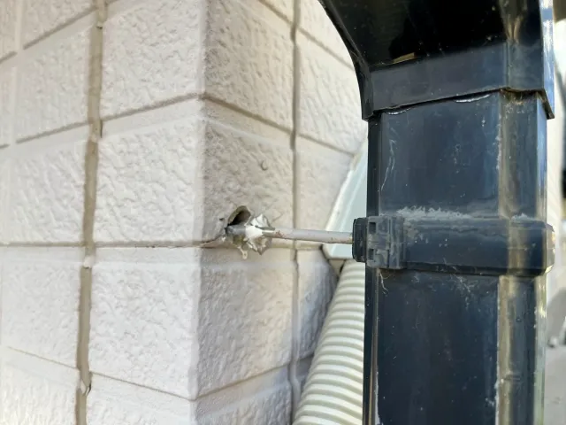 富山市の住宅で、軒樋がたわんでラインが波打っていないか、金具の外れがないかを地上から確認する様子