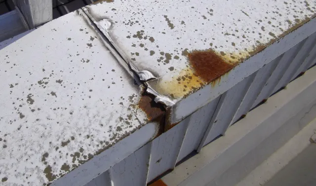 富山市のベランダで、防水層のひび割れや膨れ、排水口まわりの水たまりを確認して修理方法を見極める様子